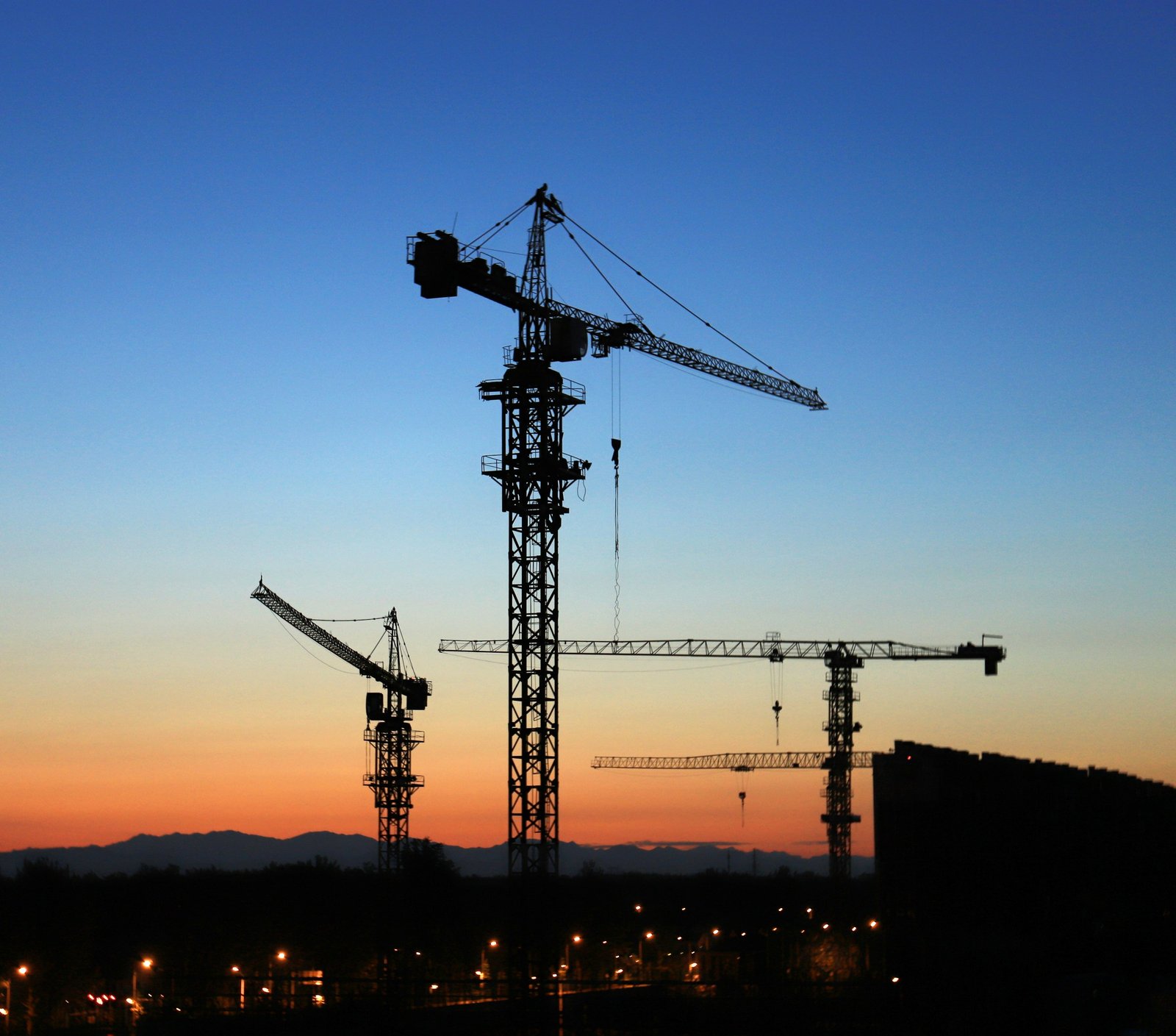 Tower cranes on a construction site at sunset