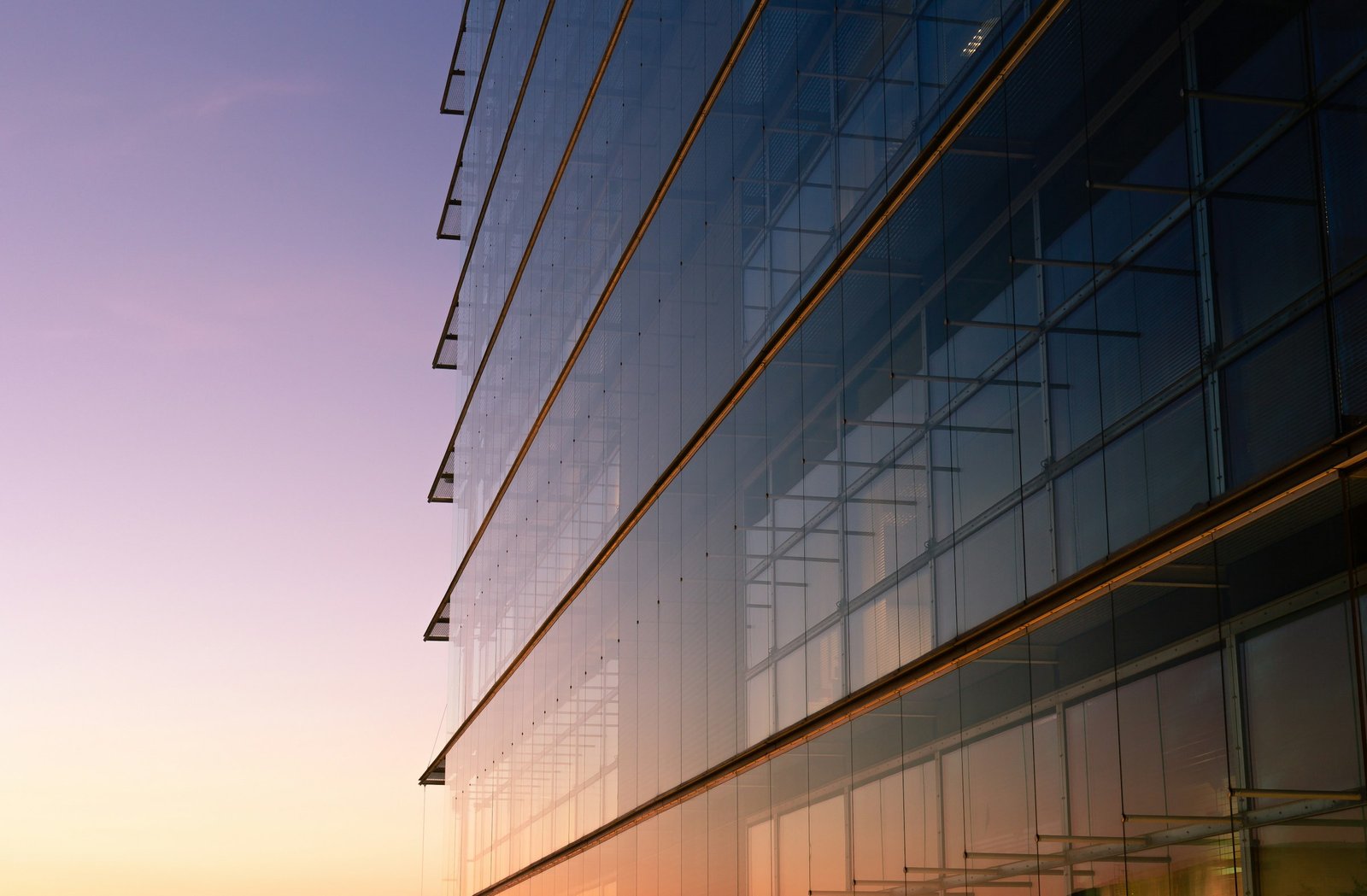 Modern glass curtain wall facade at dusk